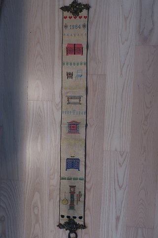 Gammel klokkestreng med broderi til illustration af 6 antikke forskellige møbler: Standkiste = Kiste til opbevaring + Stol + Bord + Vægskab + Dragkiste = Kommode + StandurHåndbroderet med korsstingFra 1964Bemærk det meget smukke ophæng