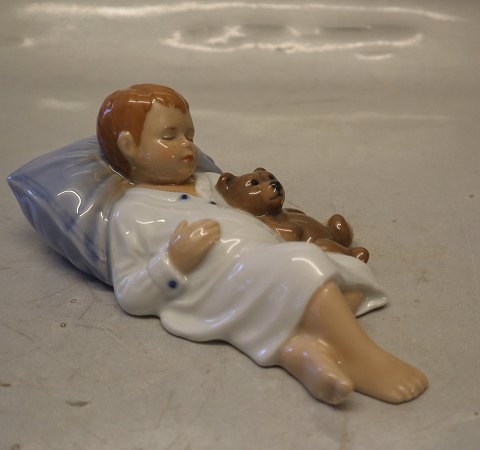 0681 Kgl. Jens sovende, Dreng sover med bamse, 6 x 11 cm (1021681) Allan 
Therkelsen Kongelig Dansk Porcelæn