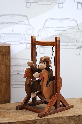 Sød , lille plys abe siddende i gammel træ gynge...