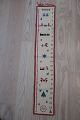 PakkekalenderSmuk, gammel, håndbroderet pakkekalender med ringe til at binde pakkerne fast iFlot håndarbejdeH: 90cm, B: 16cmGod standAntikt, dansk linned og olmerdug er vores speciale, og vi har altid et bredt udvalg