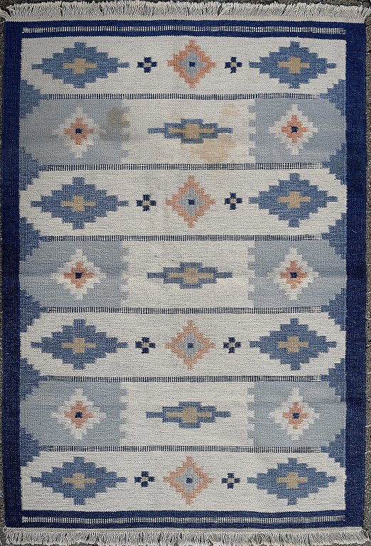 Rölakan tæppe med geometrisk mønster i blå nuancer. 
