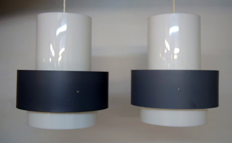 Louis Poulsen: Sæt på to pendler med skærme af grå metal samt hvidt plastik. Udført hos Louis Poulsen.