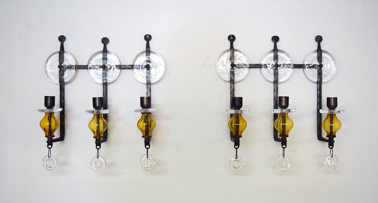 Erik Höglund for Kosta Boda. Et par 3-armede væglysestager i støbejern med mundblæste glas.