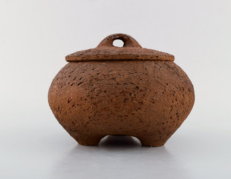 Gutte Eriksen: f. Rødby 1918, d. 2008.   Stor unika lågkrukke på fødder i stentøj. Rakubrændt teknik. 1960