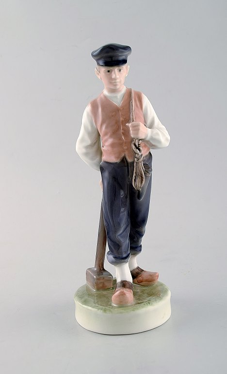 Royal Copenhagen porcelain figurine. Farmer / Guardian boy with lumber hammer. Model Number: 620.