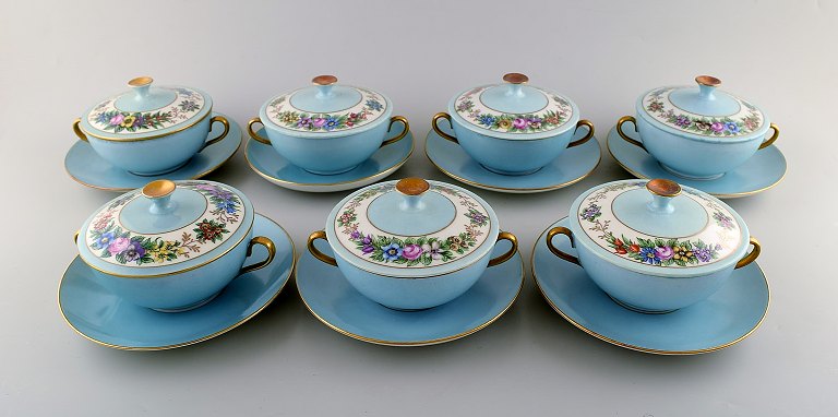 Seven early Bing and Grondahl boullion cups with lids and saucers. Hand painted gold and floral decoration on turquoise background. Overglaze. Ca. 1910.