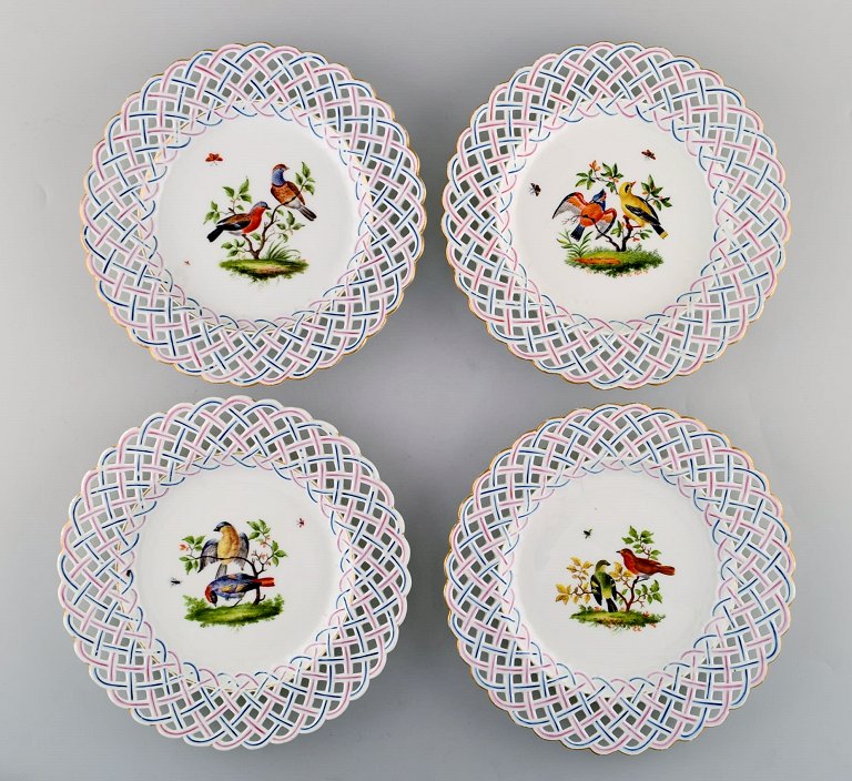 Four antique pierced Meissen plates with hand painted bird motifs. Mid 19th century.