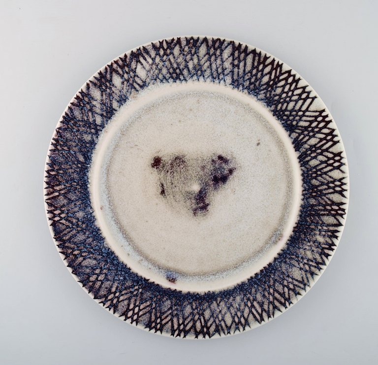 Stig Lindberg for Gustavsberg Studiohand. Large dish in glazed ceramics. Beautiful glaze in violet tones. Mid 20th century.