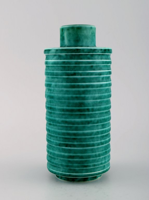 Wilhelm Kåge for Gustavsberg. Rare cylindrical Argenta art deco vase in glazed ceramics. Beautiful glaze in shades of green and grooved body. 1940