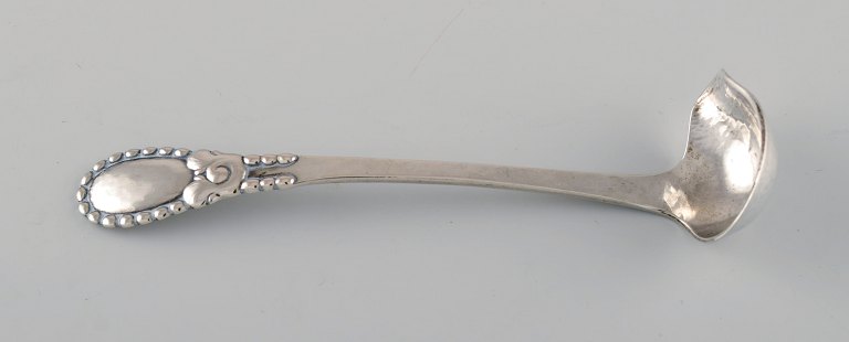 Evald Nielsen number 13 butter sauce spoon in hammered silver (830). Dated 1924.