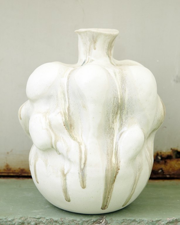 Christina Muff, Danish contemporary ceramicist (b. 1971). Large hand modeled sculptural vase with a bottleneck opening, made in soft white stoneware clay. The vessel is covered in cream white glaze and has glazedrips in golden and grey notes.