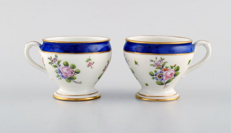 Sevres, France. Two antique cream cups in hand-painted porcelain with flowers and gold decoration. 19th century.