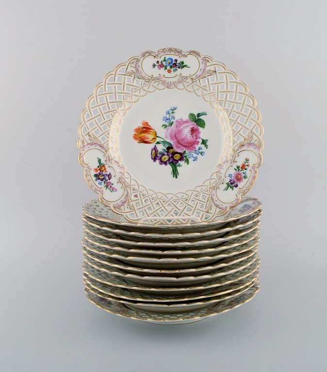 12 antikke Meissen gennembrudte tallerkener i håndmalet porcelæn med blomster og gulddekoration. Ca. 1900.