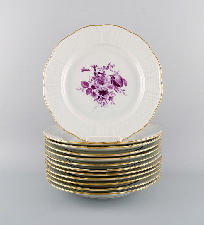 Tolv antikke Meissen middagstallerkener i håndmalet porcelæn med lilla blomster og guldkant. Ca. 1900.