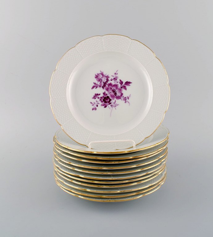 Twelve antique Meissen plates in hand-painted porcelain with purple flowers and gold edge. Ca. 1900.
