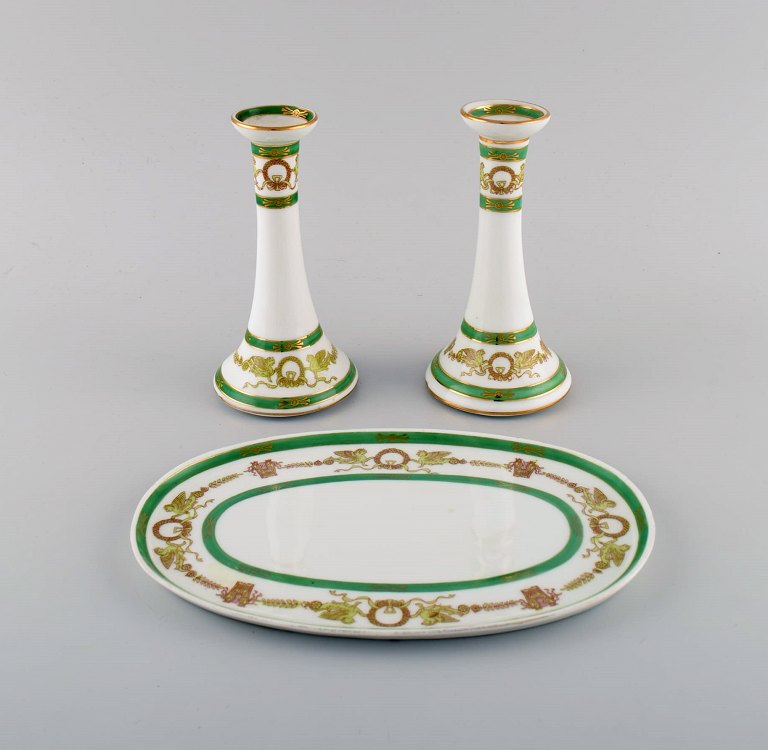 Limoges, France. Two candlesticks and a dish in hand-painted porcelain with green edge and gold decoration. 1930s / 40s.
