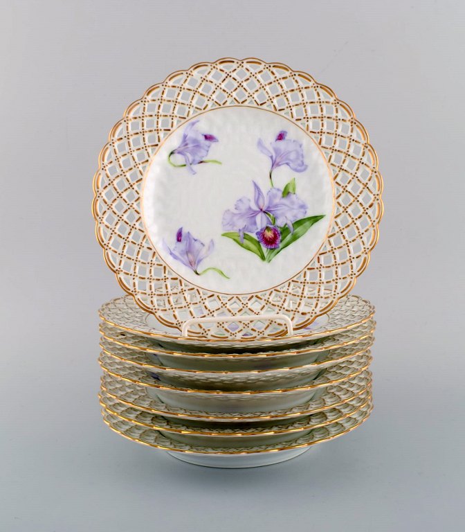 Otte antikke Royal Copenhagen tallerkener i gennembrudt porcelæn med håndmalede lilla lotusblomster. Modelnummer 72/1135. Museumskvalitet. Ca. 1910.