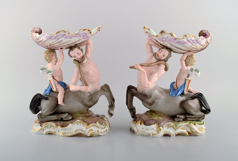 A pair of antique figurative Meissen compotes in hand-painted porcelain. Puti on centaur carrying large seashell. Museum quality. Dated 1815-1860.