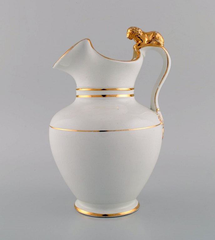 Antique Gustafsberg chocolate jug in porcelain modeled with a lion on the handle. Hand-painted gold decoration. Late 19th century.