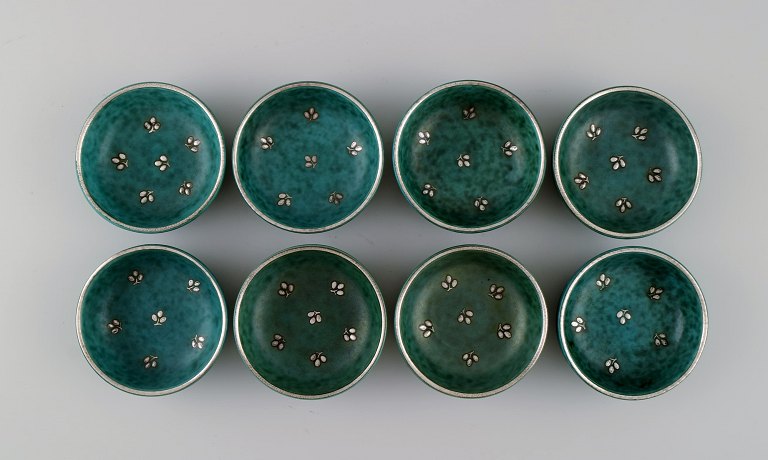 Wilhelm Kåge (1889-1960) for Gustavsberg. Eight small Argenta bowls in glazed ceramics. Beautiful glaze in shades of green with silver inlay in the form of leaves. Mid 20th century.