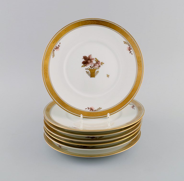 Seven Royal Copenhagen Golden Basket porcelain lunch plates with flowers and gold decoration. Model number 595/10521.