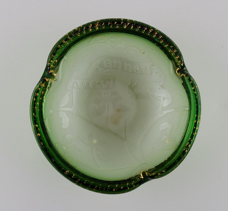 Daum Nancy, Frankrig. Art nouveau skål i grønt mundblæst kunstglas. Blomster i relief og håndmalet gulddekoration. Ca. 1900.