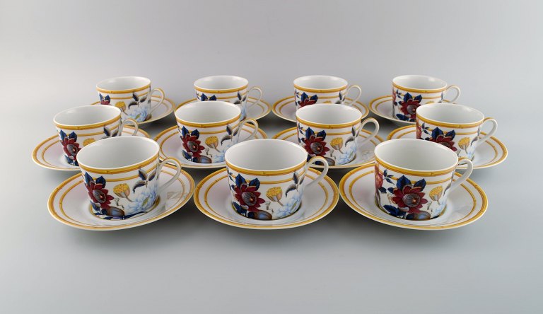 Porcelaine de Paris. "Aurore Tropicale". 11 coffee cups with saucers decorated with flowers and pomegranates. 1980s.