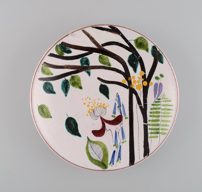 Stig Lindberg for Gustavsberg Studiohand. Round dish in glazed faience with hand-painted flowers. 1940s.