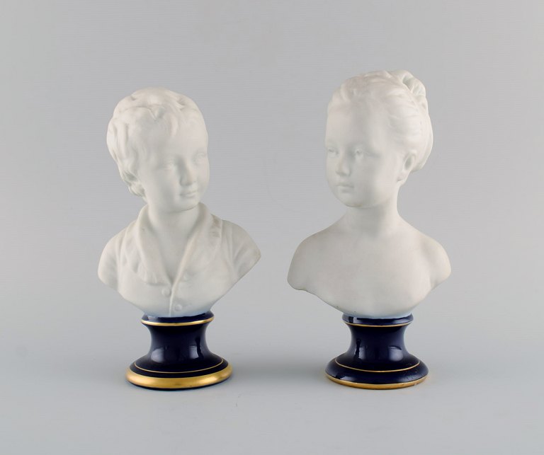 Limoges France. Two child busts in biscuit. Stand with dark blue glaze and gold edges. Classic style. Early 20th century.