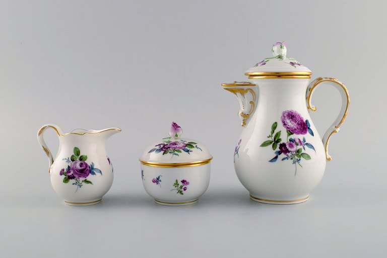 Meissen coffee pot, sugar bowl and cream jug with hand-painted flowers and gold decoration. Lids modeled with rosebuds. Early 20th century.