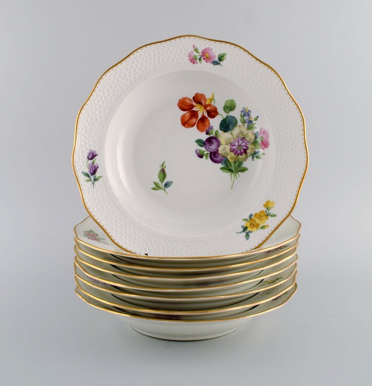 Royal Copenhagen Saxon Flower special version. Eight rare deep plates with hand-painted flowers and gold decoration. Approx. 1900.
