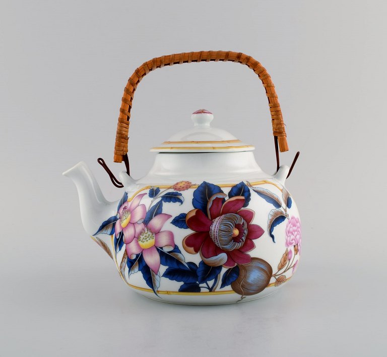 Porcelain of Paris. "Tropical Aurore". Porcelain teapot with wicker handle decorated with flowers, pomegranates and bamboo. 1980s.