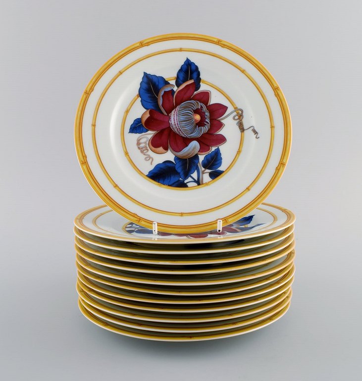 Porcelain of Paris. "Tropical Aurore". 12 porcelain lunch plates decorated with flowers and bamboo. 1980s.
