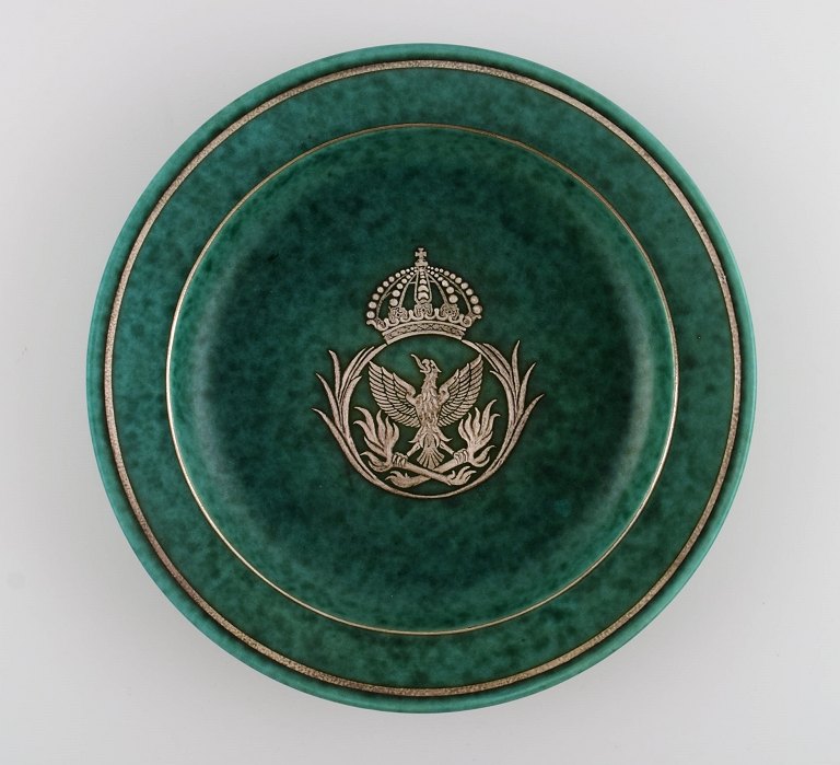Wilhelm Kåge (1889-1960) for Gustavsberg. Argenta art deco dish in glazed ceramics. Beautiful glaze in shades of green with silver inlay in the shape of an eagle and a royal crown. Mid-20th century.