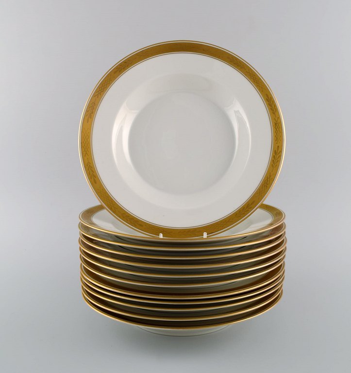 Royal Copenhagen service no. 607. Twelve deep porcelain plates. Gold border with foliage. Model number 607/9587. Dated 1944.