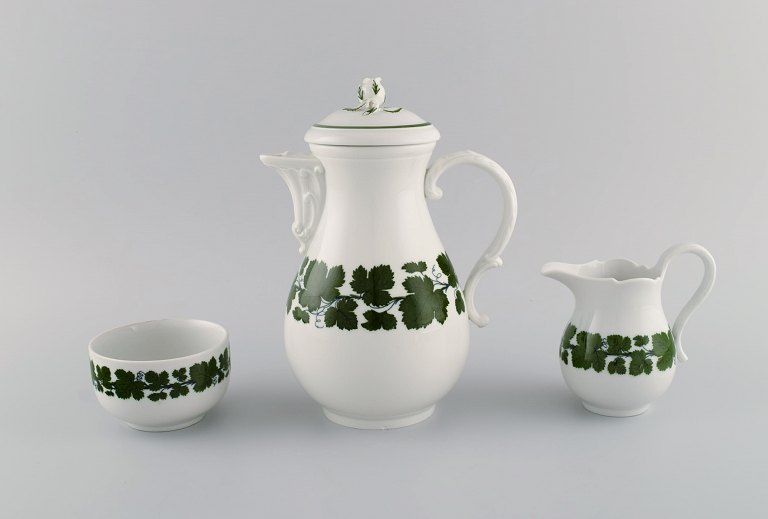 Meissen Green Ivy Vine. Coffee pot, sugar bowl and creamer in hand-painted porcelain. Lid modeled with rose bud. 1940