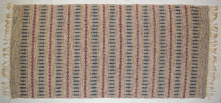 Swedish textile designer, handwoven carpet with fringes in wool.Modern design with geometric pattern.