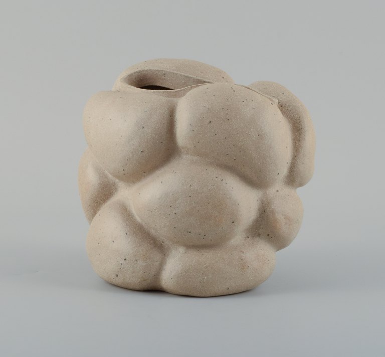 Christina Muff, Danish contemporary ceramicist (b. 1971). Creamy grey unglazed stoneware vessel with dark specks. Organically shaped. Clear glaze inside.
