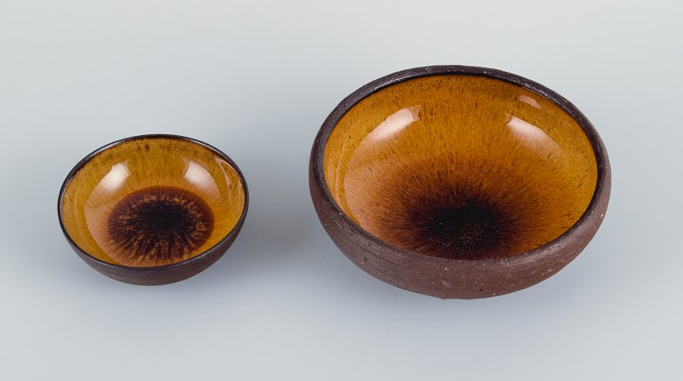 Osa, Denmark.Two small retro unique ceramic bowls with glaze in yellow-brown tones.
