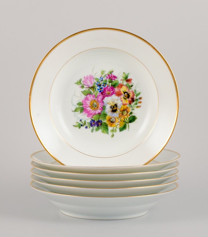 Bing & Grøndahl, six deep plates in porcelain hand-painted with polychrome 
flowers and gold decoration.
