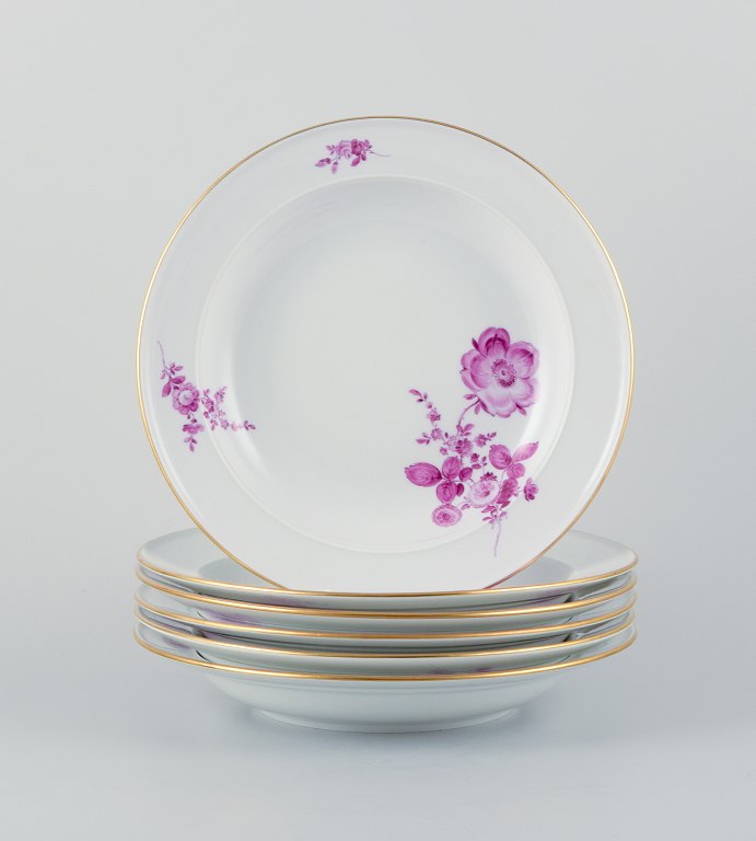 Meissen, a set of six deep porcelain plates hand-painted with flower motifs in purple. Gold decoration on the rim.