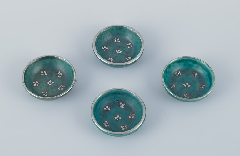 Wilhelm Kåge for Gustavsberg, a set of four small Argenta ceramic bowls inlaid with silver leaf motifs.
