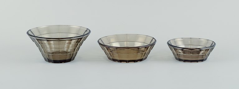 Simon Gate (1883-1945) for Orrefors/Sandvik, Sweden.A set of three Art Deco bowls in smoked coloured pressed glass.