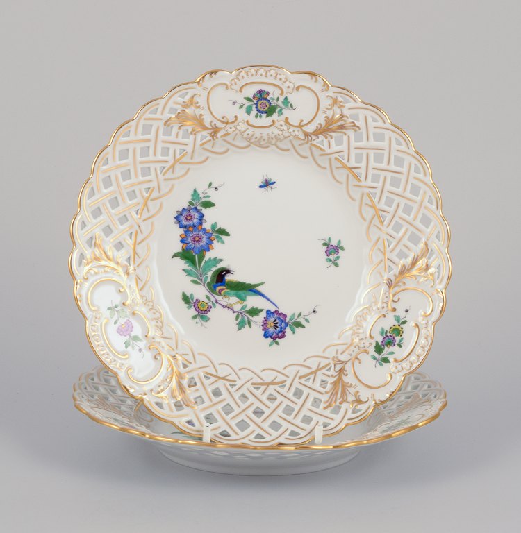Meissen, Germany. Two open lace plates in porcelain, decorated in gold with an exotic bird on a flower branch.