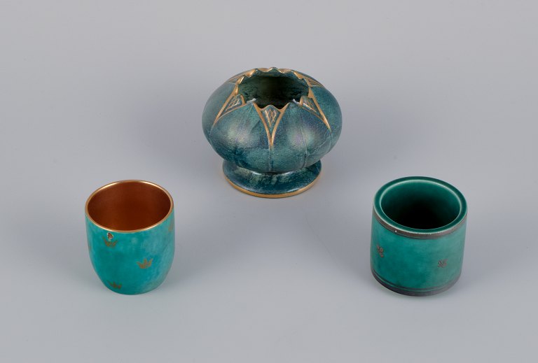 Josef Ekberg and Wilhelm Kåge for Gustavsberg, Sweden. A set of three small vases in different sizes. Green glaze with flower motifs inlaid in silver and gold.