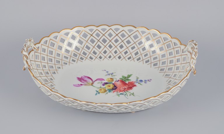 Meissen, Germany. Colossal open lace oval bowl. Hand-painted with polychrome flower motifs and gold trim.
