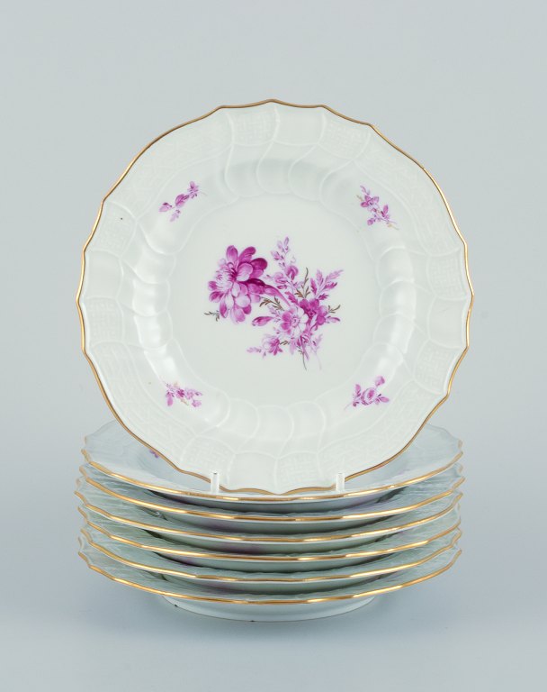 Meissen, Germany. A set of seven porcelain plates hand-painted with purple flower decoration and gold trim.