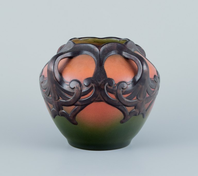 Ipsens, Denmark. Ceramic vase in Art Nouveau style.Design depicting plant growth. Glaze in orange and green tones.