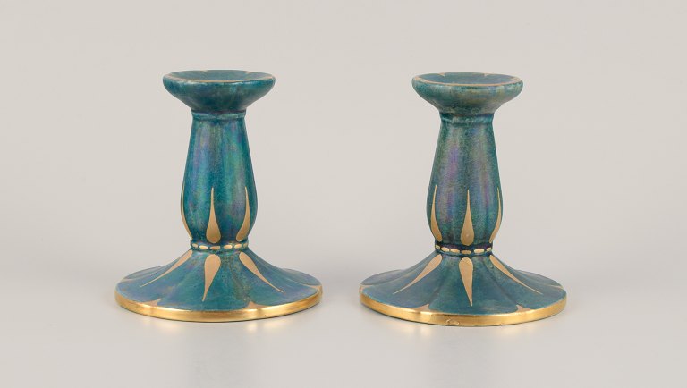 Josef Ekberg (1877-1945) for Gustavsberg, Sweden. A pair of candle holders with glaze in green-blue tones, gold decoration.