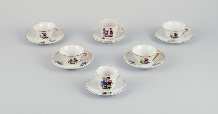 French dolls dinnerware/childrens tea set in porcelain.Six cups with matching saucers. Gold rim. Motifs of children.